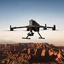 DJI Matrice 400 - Pokročilý dron so zabudovanou kamerou letí nad horským terénom počas západu slnka.